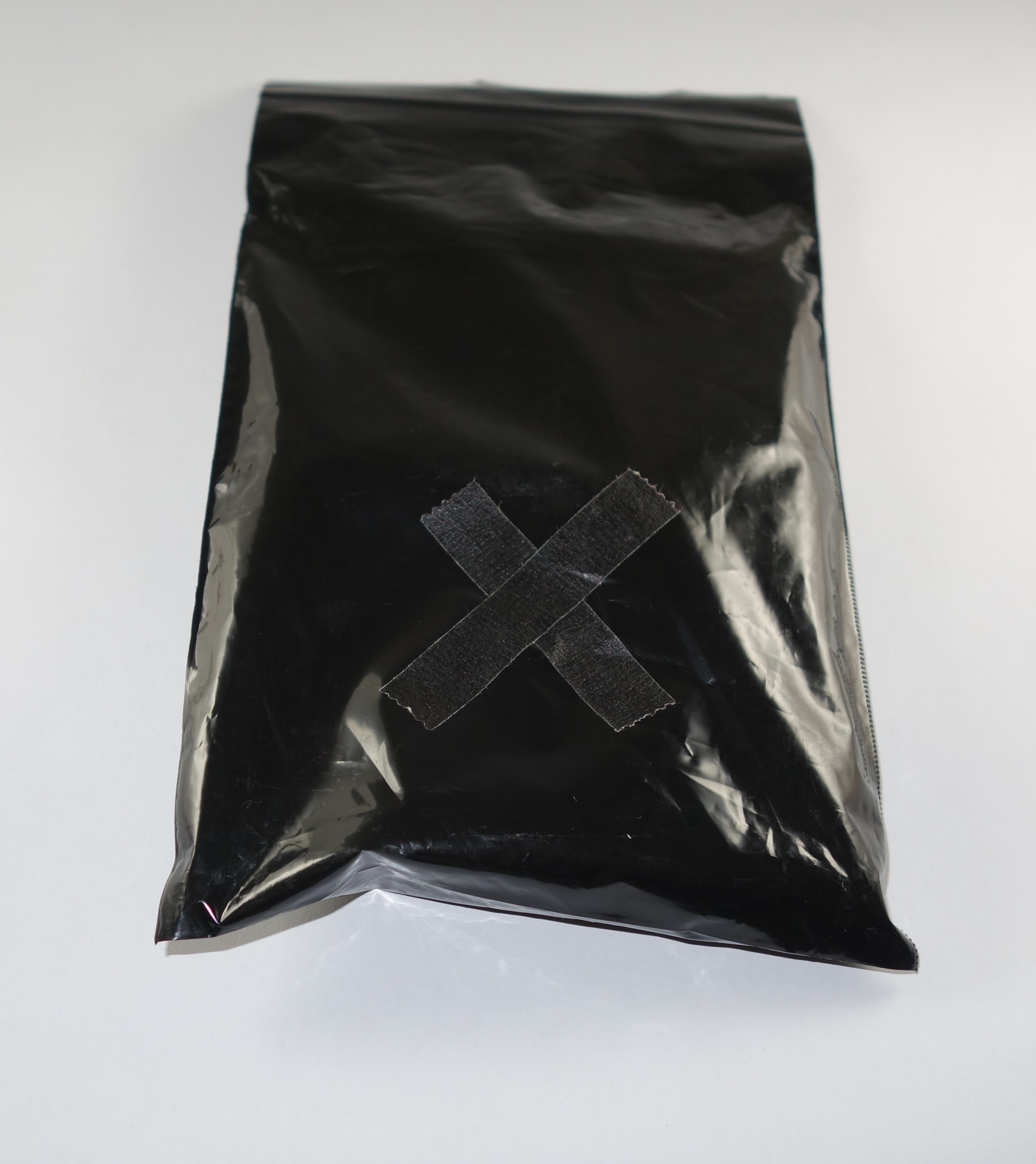 The Tar Field Notes arrive in a black bag  with a tape "X"